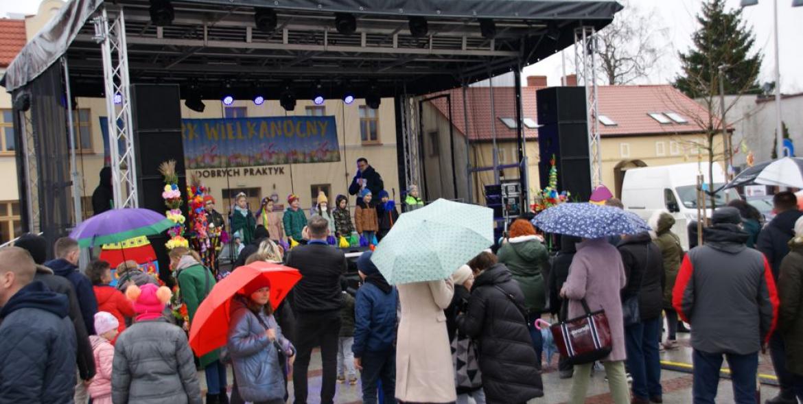 Publiczność z parasolami przed sceną.
